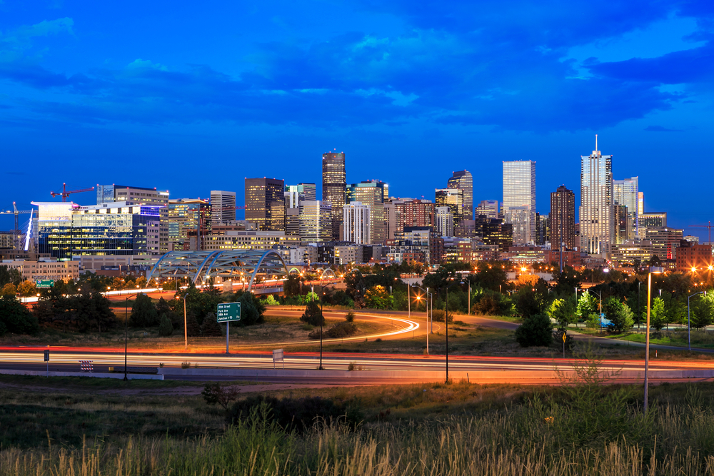 Denver skyline at dusk with Rocky Mountains in the background