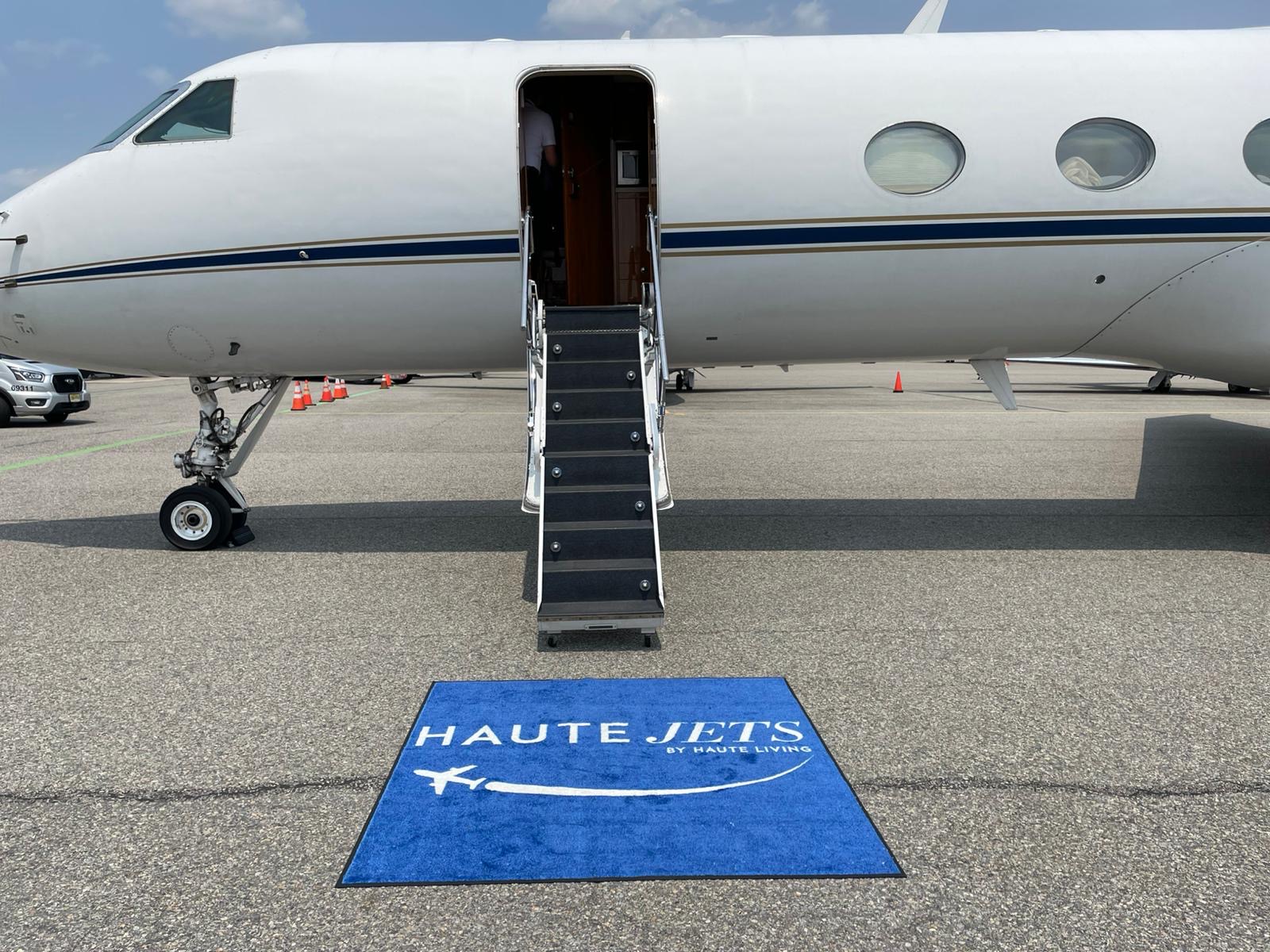 Private jet on tarmac at sunset with red carpet