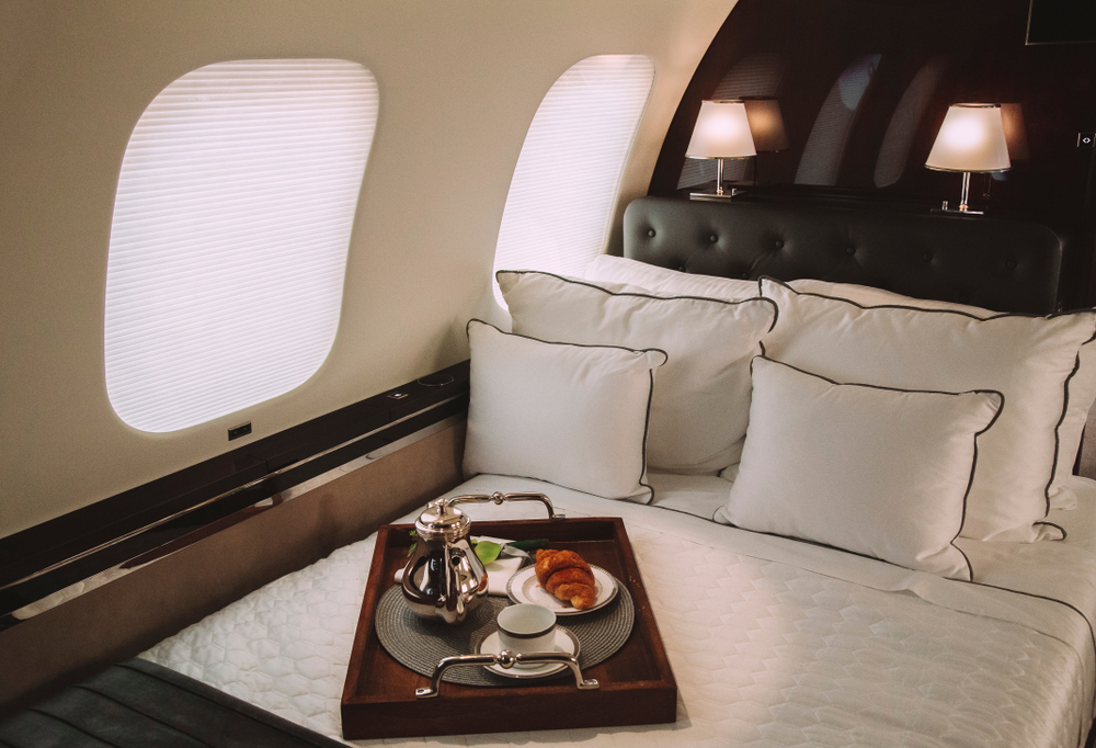 Luxury private jet interior with premium bedding and breakfast service