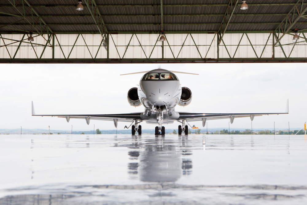 Private jet parked in hangar — Haute Jets crypto charter