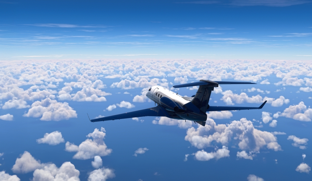 Private jet flying above the clouds